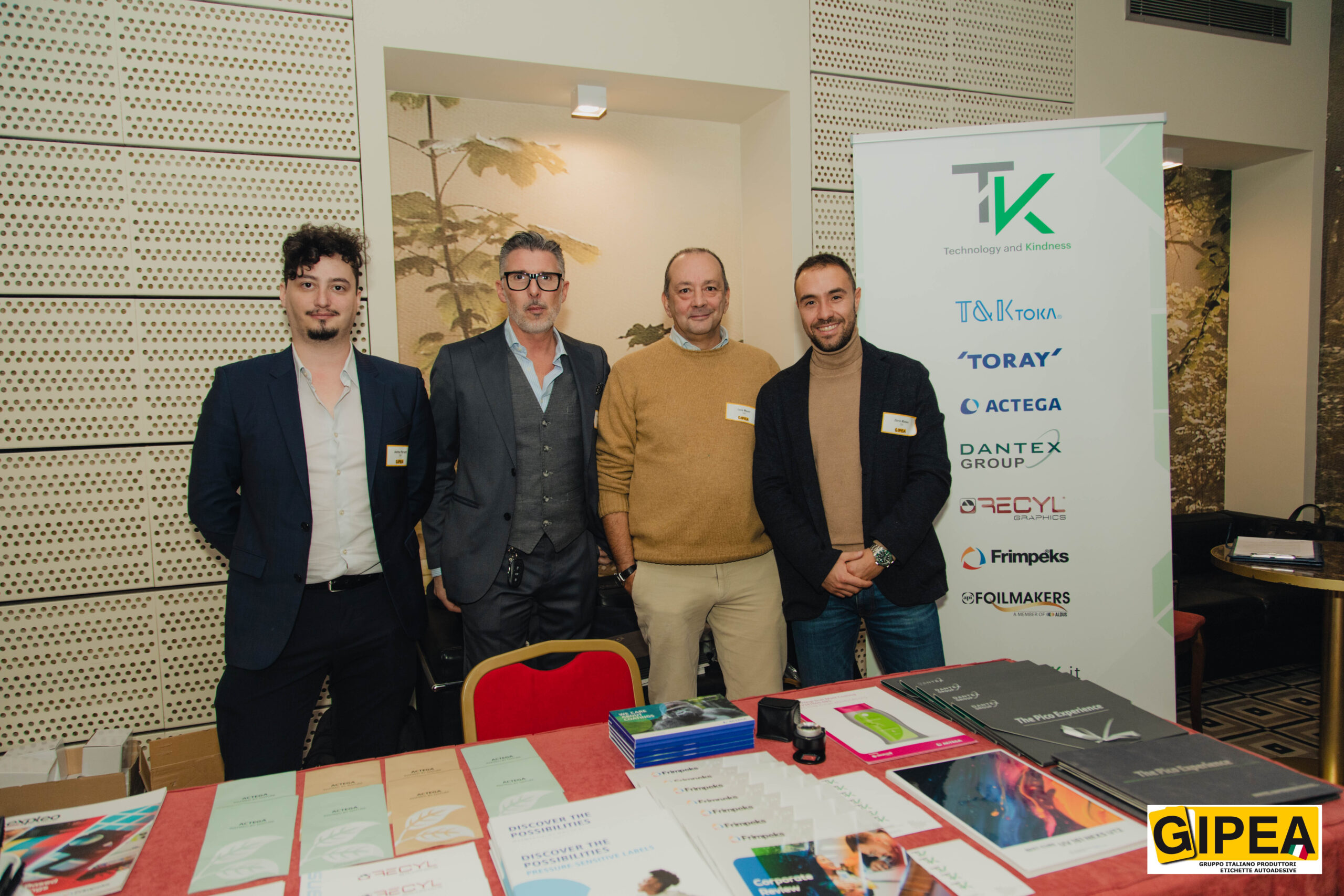 T&K ha partecipato al Convegno GIPEA del 22 novembre come Silver Sponsor. Nella foto si possono ammirare i 4 sorridenti portavoce di T&K che hanno presenziato al Congresso: Luca Mauri, Technical Manager, I due Sales Manager Dario Madau ed Enrico Stivanello e Andrea Parietti, Product Manager divisione Inkjet. In primo piano il tavolino riservato a T&K con i flyer TOKA, ACTEGA, RECYL, FRIMPEKS mentre sullo sfondo si slancia in tutto il suo splendore il nuovo Roll up di T&K.